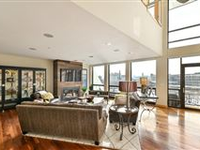 WATCH THE BUZZ OF THE CITY IN MOTION FROM THIS TOP FLOOR, SUN-DRENCHED BI-LEVEL CONDO